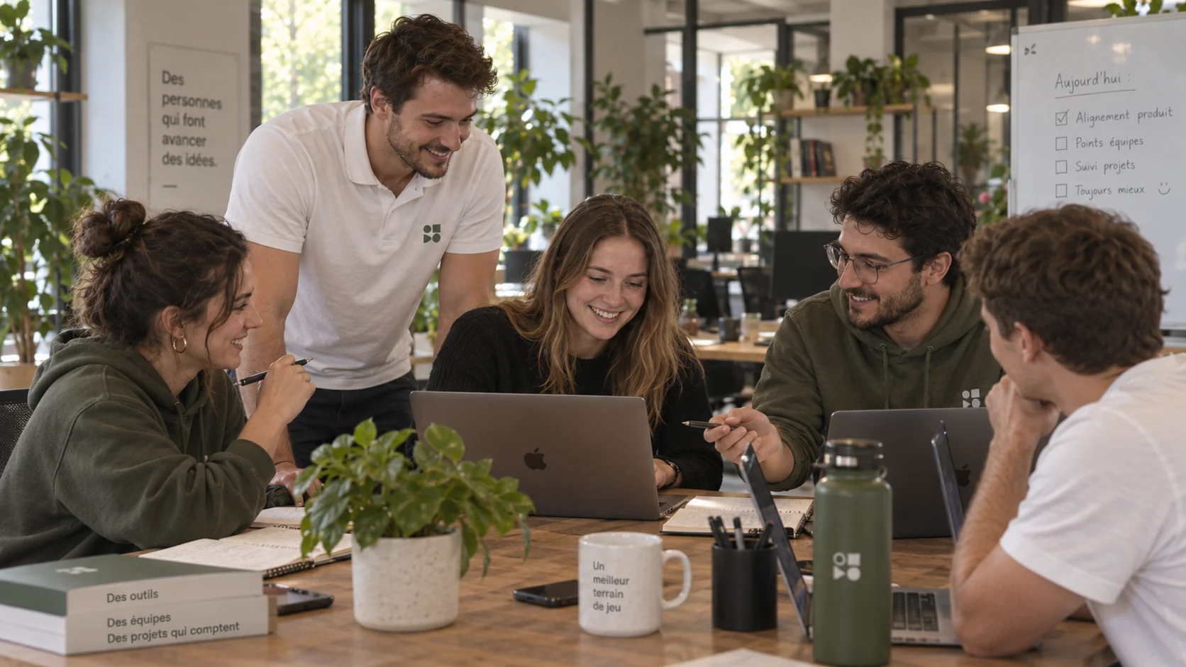 Une équipe collabore autour de ses ordinateurs dans un bureau lumineux.